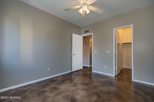 unfurnished bedroom with ceiling fan, a walk in closet, and a closet