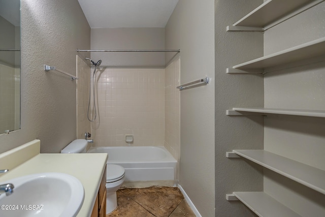 full bathroom with tile patterned flooring, vanity, toilet, and tiled shower / bath