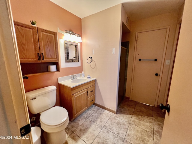 bathroom featuring vanity, tile patterned floors, toilet, and walk in shower