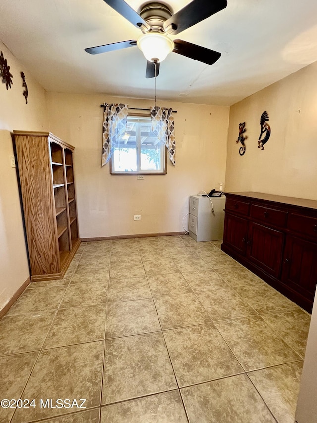 tiled spare room featuring ceiling fan