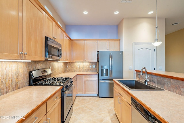 kitchen featuring light brown cabinets, hanging light fixtures, sink, decorative backsplash, and appliances with stainless steel finishes