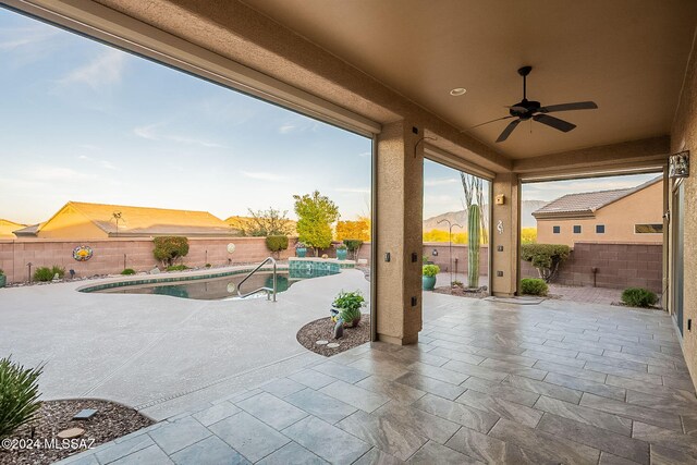 view of patio / terrace featuring a mountain view, a fenced in pool, and ceiling fan