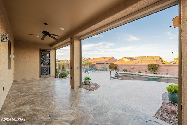 view of patio with ceiling fan and a fenced in pool