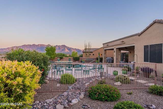 pool at dusk featuring a mountain view and a patio area