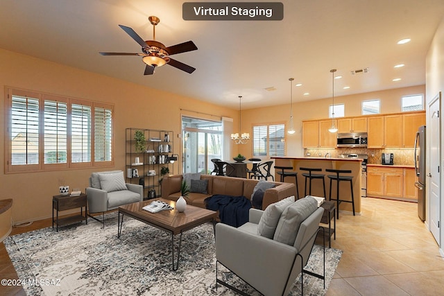 tiled living room featuring ceiling fan with notable chandelier