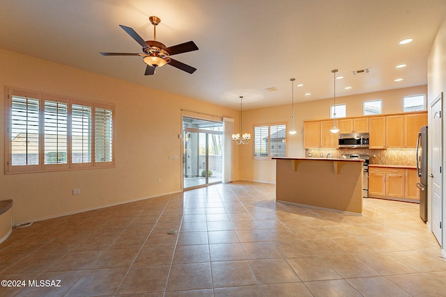 kitchen with appliances with stainless steel finishes, a center island, decorative light fixtures, and light tile patterned flooring