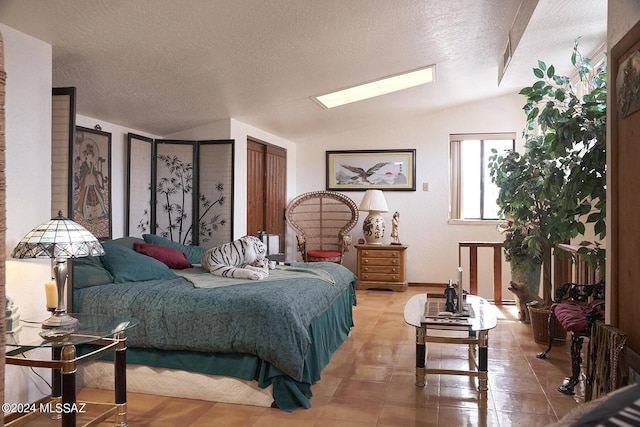 bedroom featuring lofted ceiling and a textured ceiling