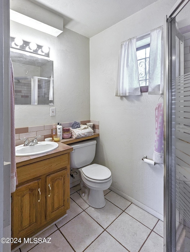 bathroom featuring vanity, toilet, tile patterned flooring, and a shower with door