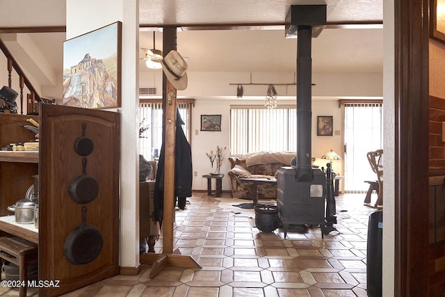 living room featuring ceiling fan and a wood stove