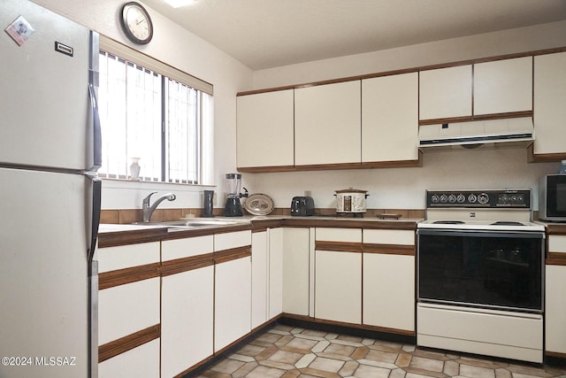 kitchen with white cabinetry, sink, and white appliances