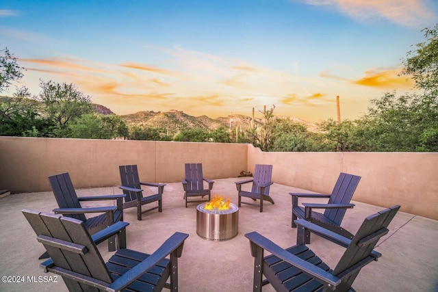 patio terrace at dusk with a mountain view and an outdoor fire pit