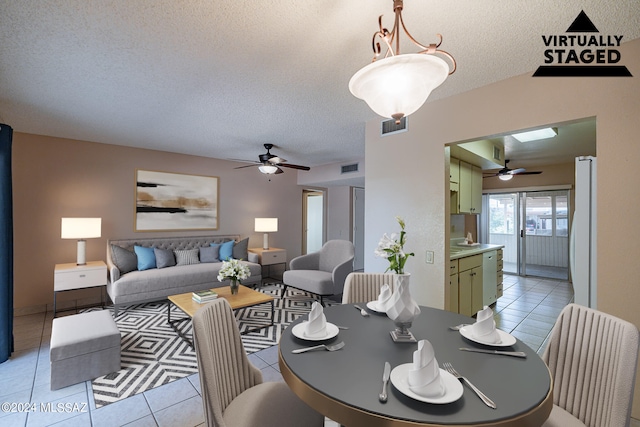 tiled dining space featuring ceiling fan, a textured ceiling, and sink