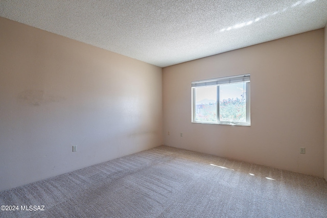 empty room with a textured ceiling and carpet floors