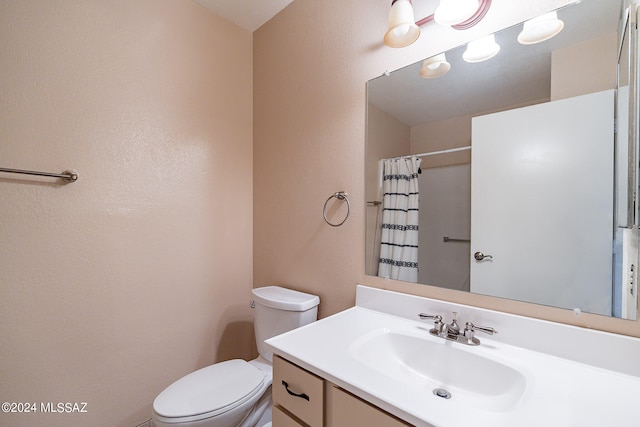 bathroom with a shower with curtain, vanity, and toilet