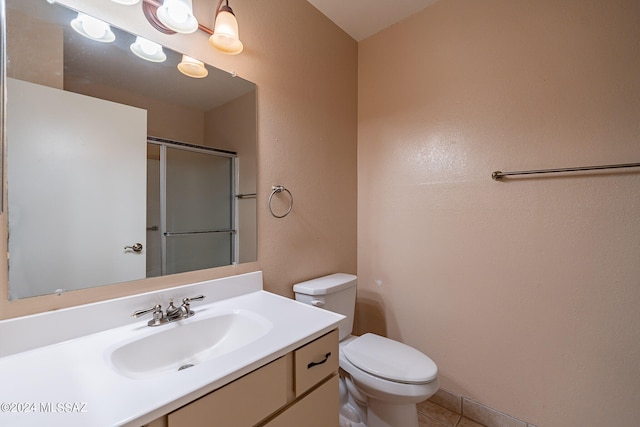 bathroom featuring vanity, tile patterned flooring, toilet, and a shower with door