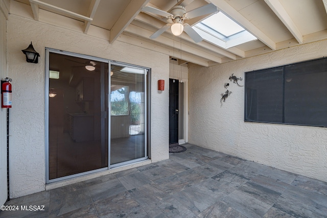 entrance to property with ceiling fan and a patio area