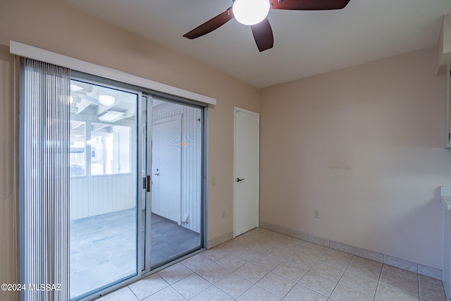 tiled spare room featuring ceiling fan