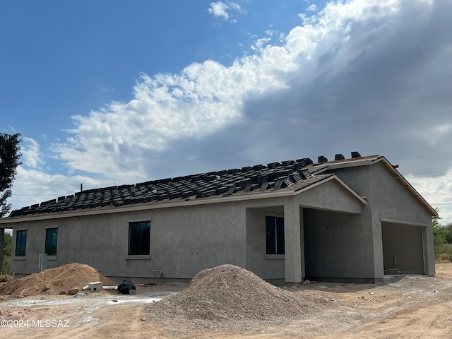 rear view of property featuring a garage