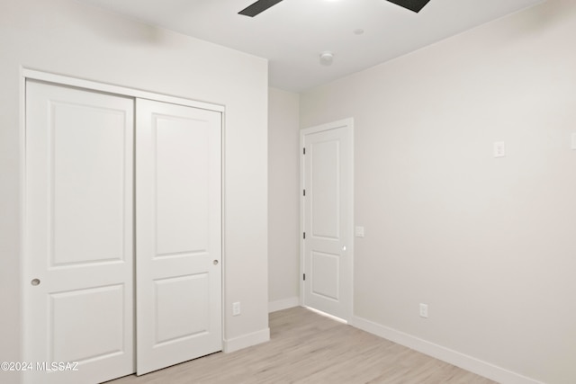 unfurnished bedroom featuring a closet, ceiling fan, and light wood-type flooring