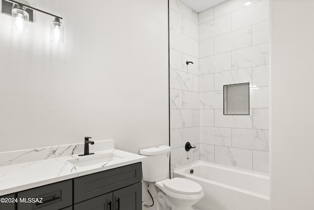 full bathroom with tiled shower / bath, vanity, and toilet