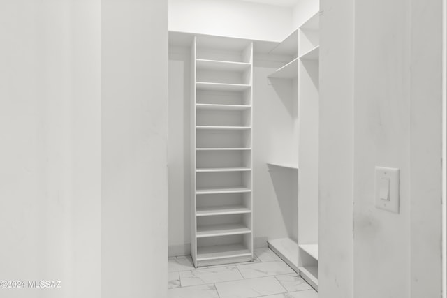 walk in closet with light tile floors