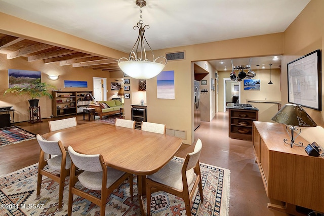 dining room featuring concrete flooring and beamed ceiling