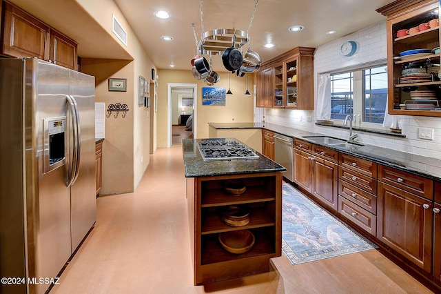 kitchen featuring backsplash, stainless steel appliances, sink, and dark stone countertops