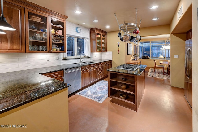 kitchen featuring pendant lighting, sink, backsplash, and stainless steel appliances