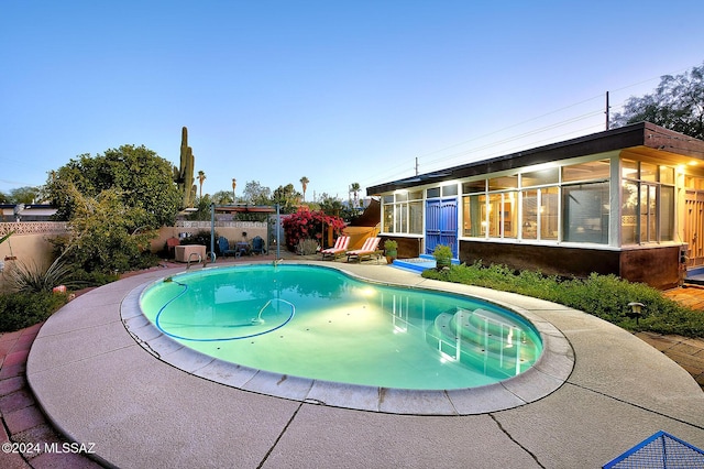 view of pool at dusk