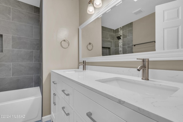 bathroom featuring tiled shower / bath and vanity