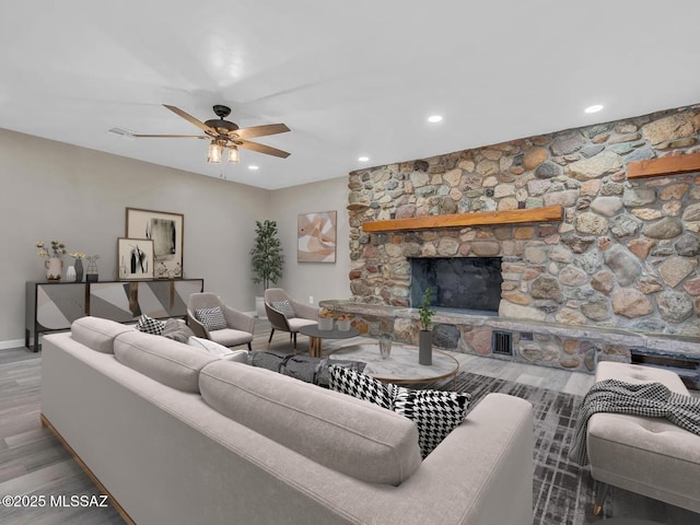 living room with ceiling fan, wood-type flooring, and a fireplace