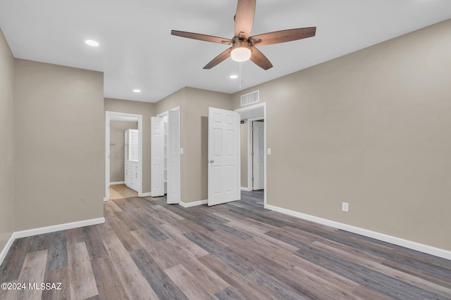 unfurnished bedroom featuring hardwood / wood-style flooring, ensuite bath, and ceiling fan