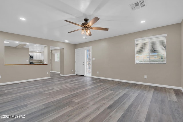 unfurnished living room featuring ceiling fan and hardwood / wood-style floors