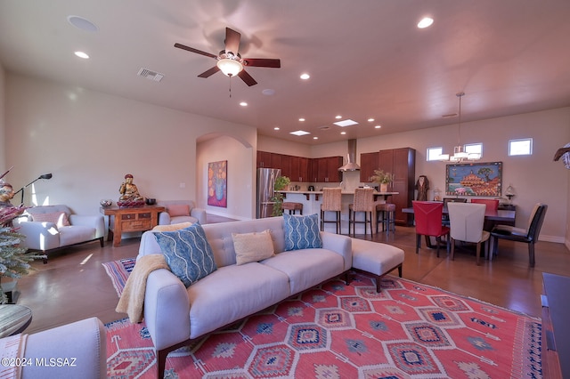 living room with ceiling fan with notable chandelier