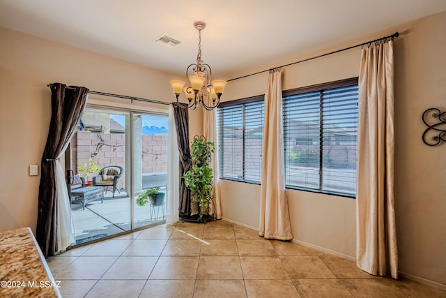 doorway to outside featuring a chandelier and light tile patterned floors