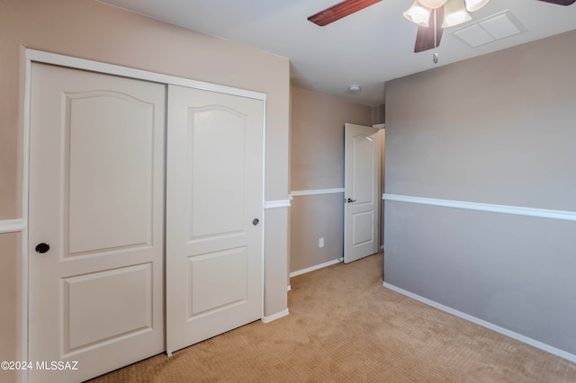 unfurnished bedroom with ceiling fan, a closet, and light carpet