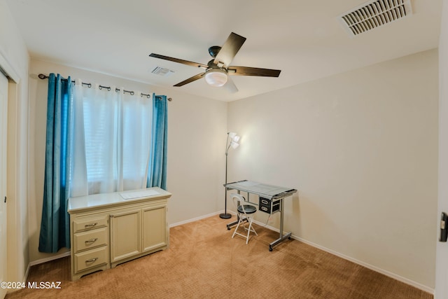 home office with light carpet and ceiling fan