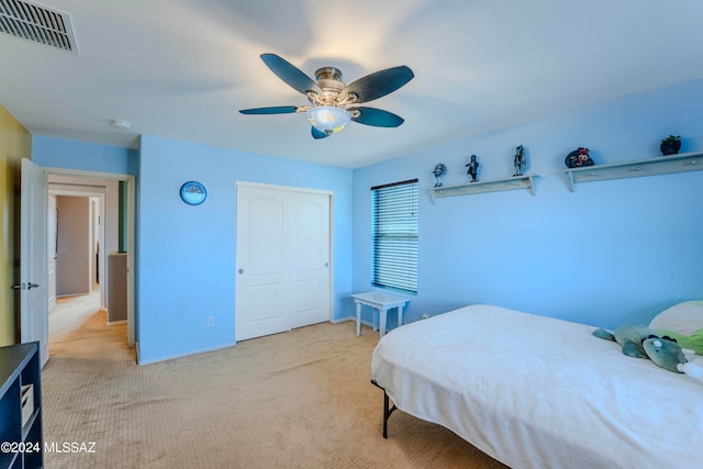 bedroom with light carpet, a closet, and ceiling fan