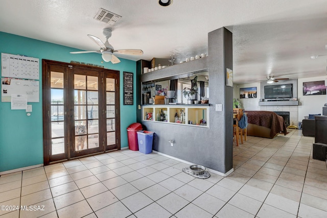 kitchen featuring ceiling fan, a textured ceiling, and light tile floors