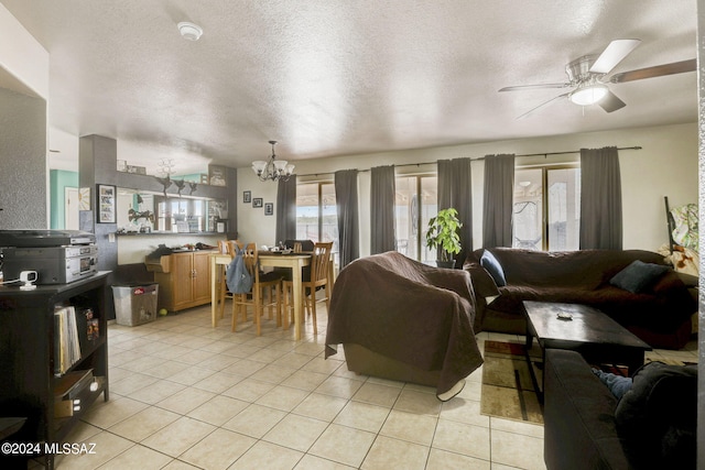 tiled living room featuring a textured ceiling and ceiling fan with notable chandelier