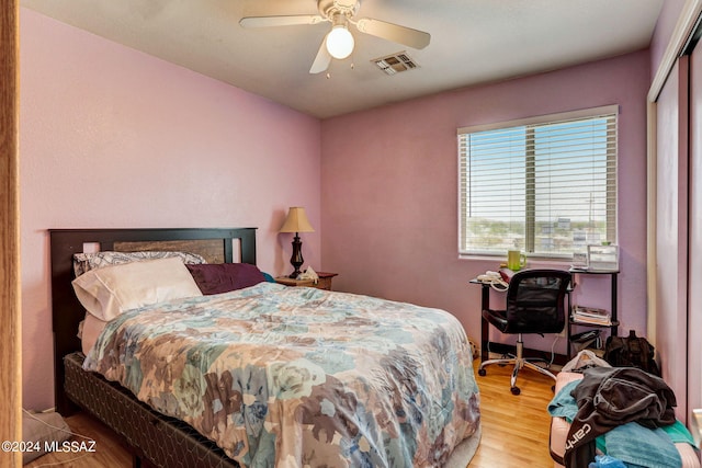 bedroom with a closet, light hardwood / wood-style floors, and ceiling fan