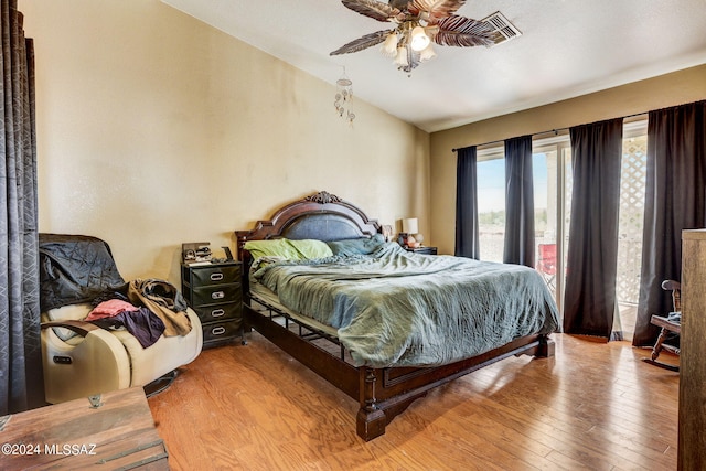 bedroom with ceiling fan, light wood-type flooring, and vaulted ceiling