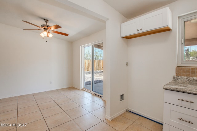 kitchen featuring ceiling fan, a healthy amount of sunlight, white cabinetry, and light tile floors