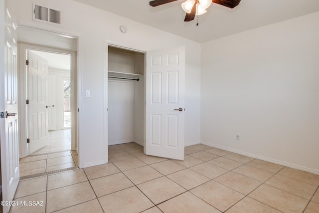 unfurnished bedroom with ceiling fan, a closet, and light tile floors