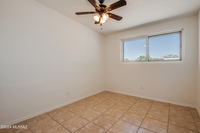 spare room with ceiling fan and light tile floors