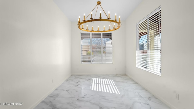 spare room with an inviting chandelier and light tile floors