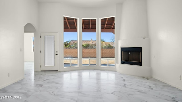 unfurnished living room with a fireplace and light tile floors