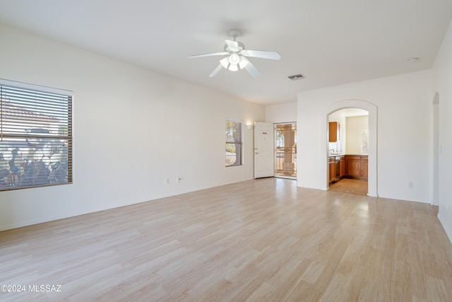 spare room with light hardwood / wood-style floors, ceiling fan, and a healthy amount of sunlight