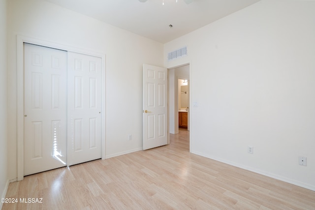 unfurnished bedroom featuring a closet and light wood-type flooring