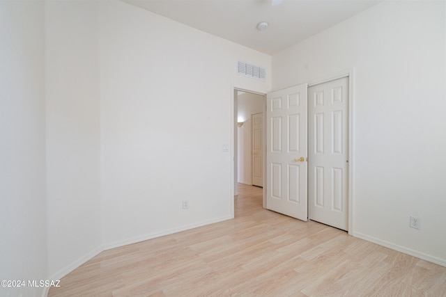 unfurnished bedroom featuring a closet and light hardwood / wood-style flooring